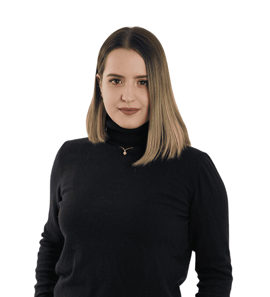 Eine Frau mit glattem, schulterlangem Haar und einem schwarzen Rollkragenpullover steht vor einem schlichten, transparenten Hintergrund mit dem Gesicht zur Kamera.