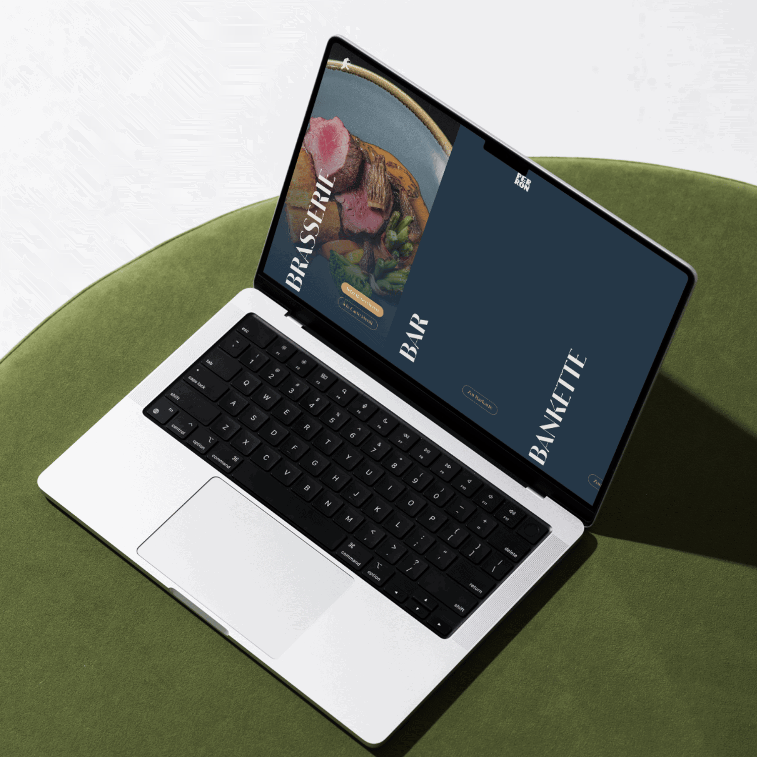 Ein Laptop auf einer grünen Fläche zeigt eine Website mit Lebensmitteln und den Texten "Brasserie", "Bar" und "Banquette" auf dunkelblauem Hintergrund, die die kreative Arbeit einer Content Agentur Basel präsentieren.