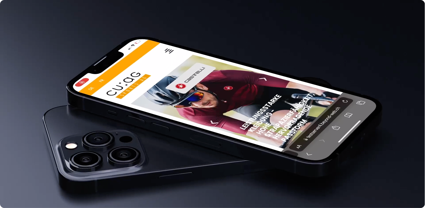 Ein schwarzes Smartphone liegt auf einem kabellosen Ladepad und zeigt eine Fahrrad-Website mit dem Foto eines Radfahrers mit Sonnenbrille und kastanienbraunem Trikot an.